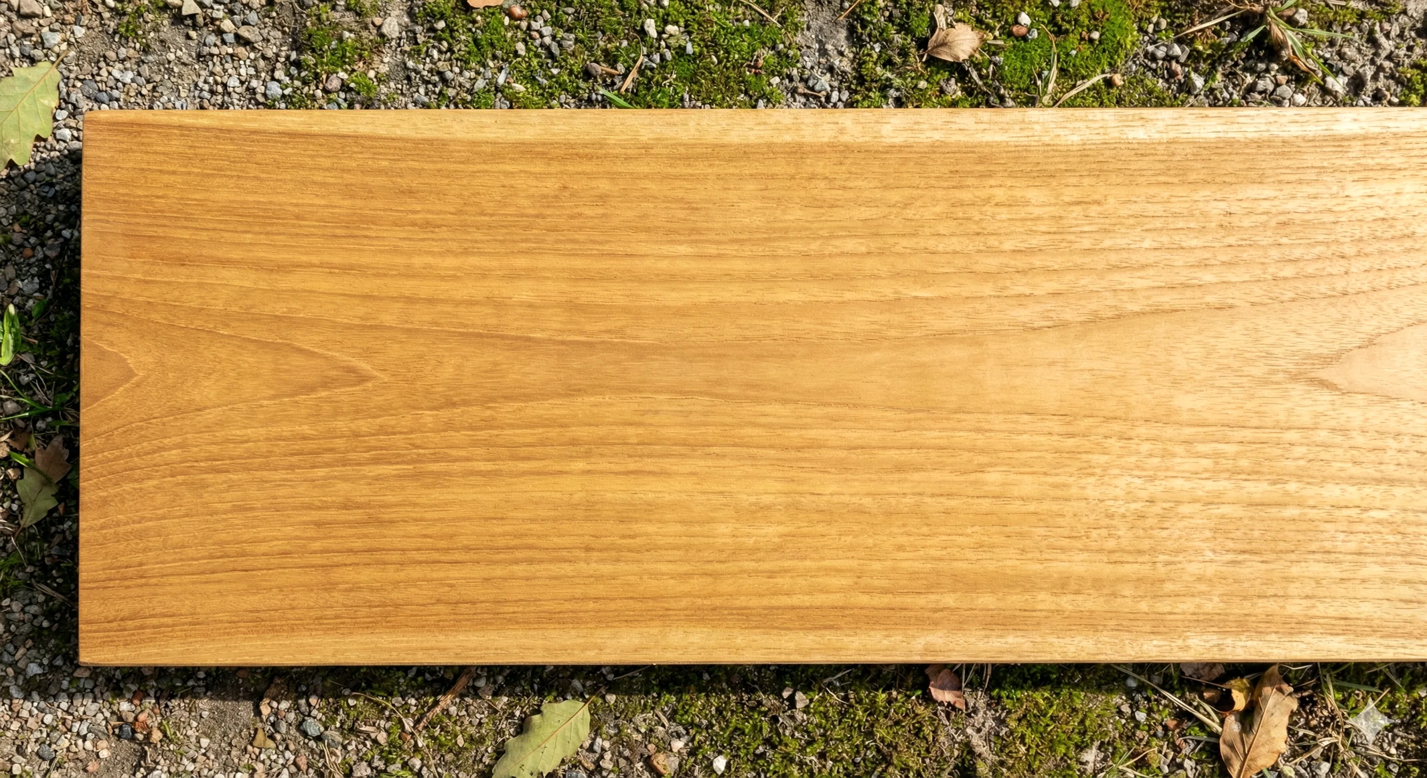 Fresh new teak wood surface with warm golden honey color and natural oily sheen